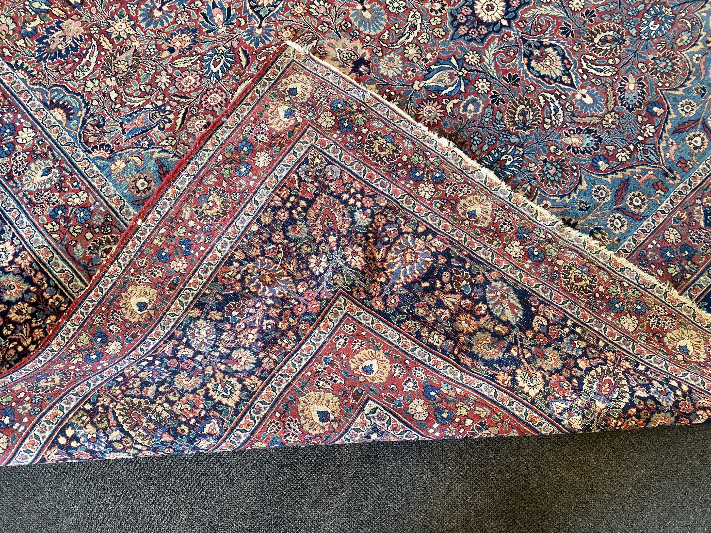 A large Persian blue ground carpet, 395 x 305cm